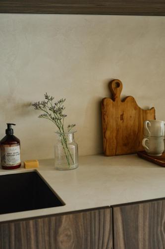 a kitchen counter with a sink and a vase with flowers at Raibu Ghent by StayC in Ghent