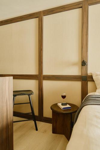 a bedroom with a bed and a table and a stool at Raibu Ghent by StayC in Ghent
