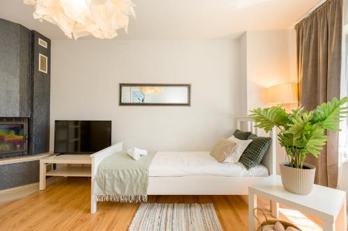 a white living room with a bed and a tv at NaNoc - noclegi obok lubelskich szpitali i centrum Lublina in Lublin