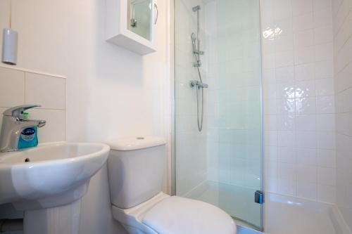 a bathroom with a toilet and a sink and a shower at 4 Bedroom City Centre Townhouse in Norwich