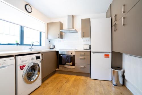 a kitchen with a washing machine and a washer at 4 Bedroom City Centre Townhouse in Norwich