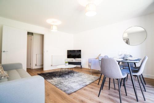 a white living room with a table and chairs at 4 Bedroom City Centre Townhouse in Norwich