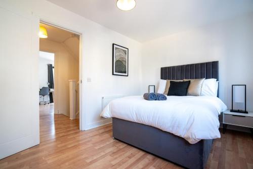 a bedroom with a large bed and a hallway at 4 Bedroom City Centre Townhouse in Norwich