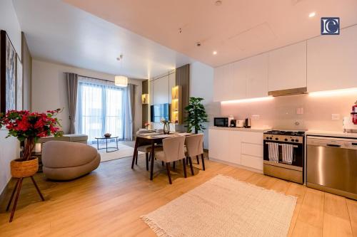 a kitchen and living room with a table and chairs at Luxury Escapes - Breathtaking 1BR with Sea View Port Lamer in Dubai