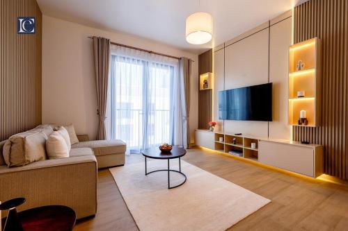 a living room with a couch and a tv at Luxury Escapes - Breathtaking 1BR with Sea View Port Lamer in Dubai