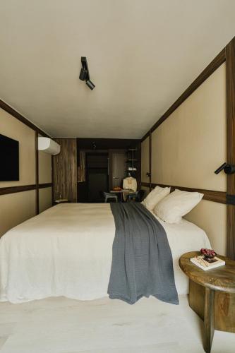 a bedroom with a large white bed and a table at Raibu Ghent by StayC in Ghent