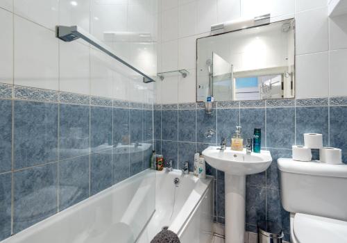 a bathroom with a tub and a sink and a toilet at The Lothian Road Residence in Edinburgh