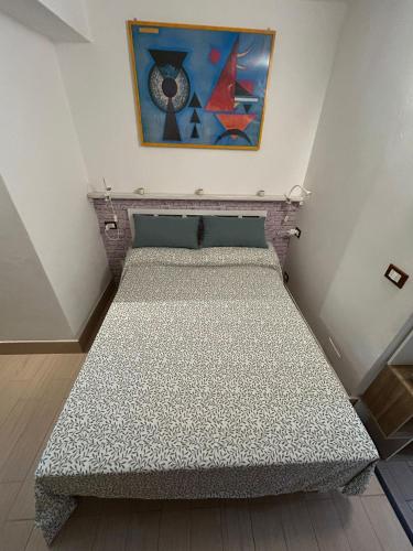 1 cama en una habitación con un cuadro en la pared en Il Rifugio nel Borgo, en Lerici