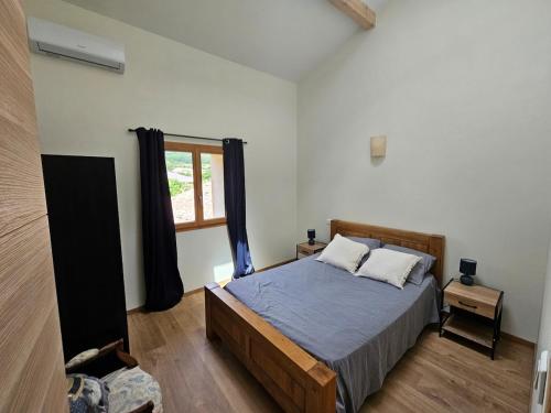 Saint-Jean-de-BuègesにあるLes mûriers de Roseのベッドと窓のある寝室