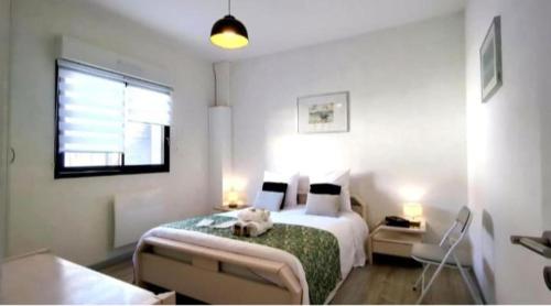 une chambre avec un lit avec un ours en peluche dessus dans l'établissement Petite maison cosy au calme, à Royan