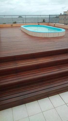 a wooden deck with a swimming pool in a building at Gaivotas Praia Hotel in São Francisco do Sul