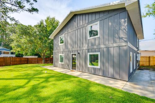 a metal building with a garage on a lawn at 3 Mi to Navarre Beach Home with Furnished Patio in Navarre