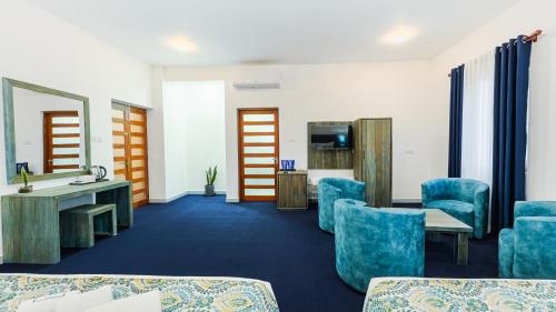 a room with blue chairs and a table and a mirror at Hasthi Boutique in Kandy