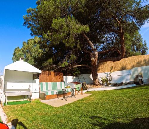 a backyard with a tree and a table and a tent at Cozy Mama Evas Homestay with Pool and Garden for Groups of 4 in Kirás Vrísi