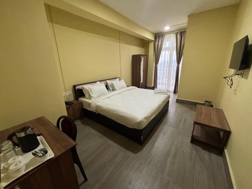 una habitación de hotel con una cama y una mesa en Hotel Jamyang, en Bomdila