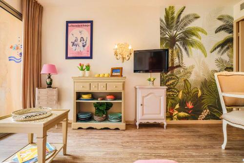 - un salon avec une télévision et une commode dans l'établissement Le Cannes Beach 497 - vue mer et piscine Cannes, à Cannes