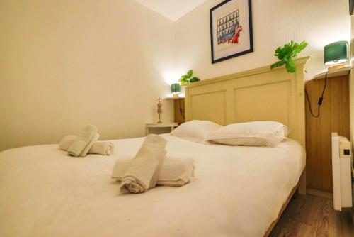 une chambre avec un grand lit blanc avec des serviettes dessus dans l'établissement Le Cannes Beach 497 - vue mer et piscine Cannes, à Cannes