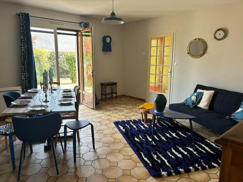 un salon avec une table et un canapé bleu dans l'établissement Chez Colette, maison agréable, à Villebernier