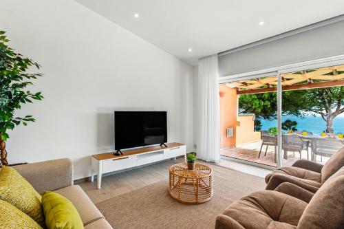 een woonkamer met een tv en een bank bij The Oceanfront Villa Luz VR114 in Luz