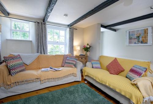 a living room with two couches and two windows at Berry Cottage in Croyde