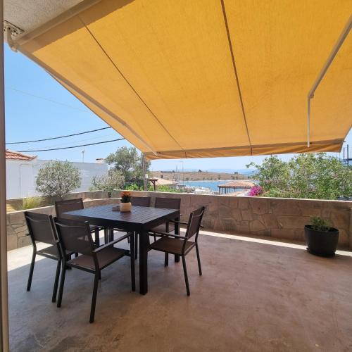 a table and chairs on a patio with a large umbrella at Katrina's Place in Perdhika