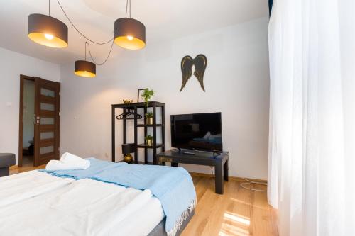a bedroom with a bed and a flat screen tv at NaNoc - noclegi obok lubelskich szpitali i centrum Lublina in Lublin