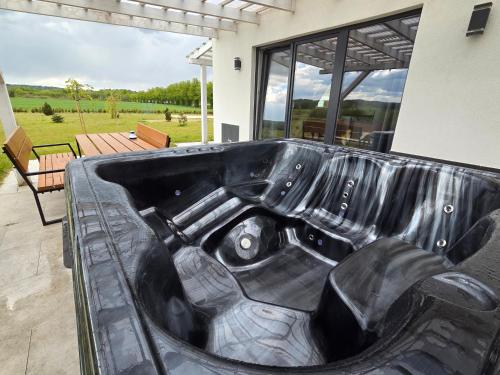 a black bathtub in the front of a house at Domek Jozef z prywatnym duzym Jacuzzi i sauna Przystan pod niebem in Leczyce