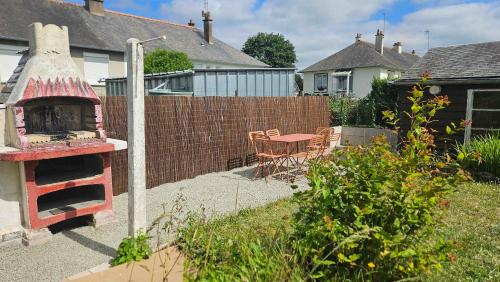 une cour arrière avec un mur de briques et un barbecue dans une cour dans l'établissement Grande maison billard et confort a Guingamp, à Guingamp