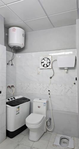 a white bathroom with a toilet and a sink at ركن دار الطائف in Taif