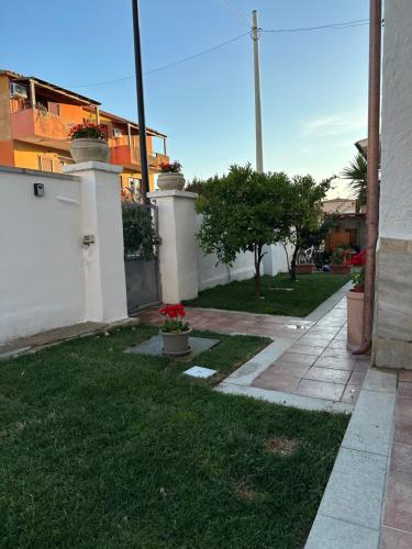 a house with a grass yard with a sidewalk at Garden House in Olbia