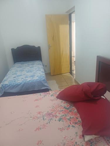 a bedroom with a bed and a door into a room at Casa da Arlete 2 in Aparecida