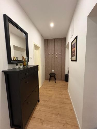 a hallway with a black dresser and a mirror at Apartment Gold Wing Sinj in Sinj