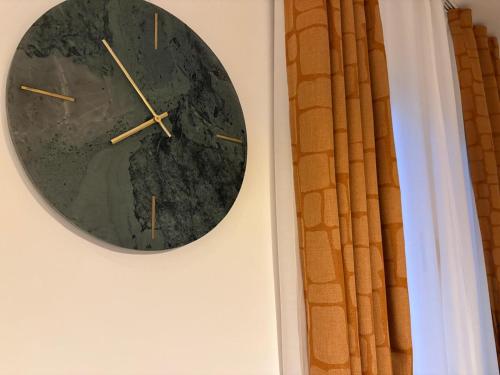 a clock hanging on a wall next to a window at Apartment Gold Wing Sinj in Sinj