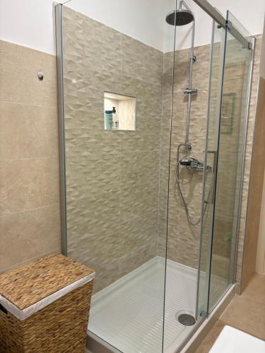 a shower with a glass door and a basket at Apartment Gold Wing Sinj in Sinj