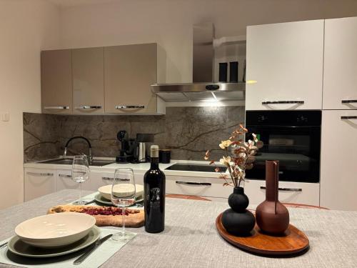 a kitchen with a table with wine bottles and glasses at Apartment Gold Wing Sinj in Sinj