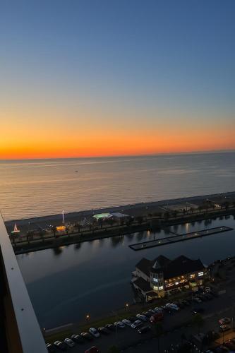 a sunset over the water and a parking lot at Orbi City - Sea View Aparthotel in Batumi in Batumi