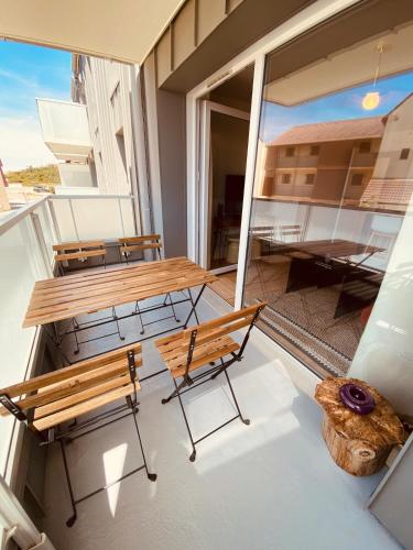 Elle comprend un balcon avec une table et des chaises en bois. dans l'établissement Camiers, Dune 105, à Camiers