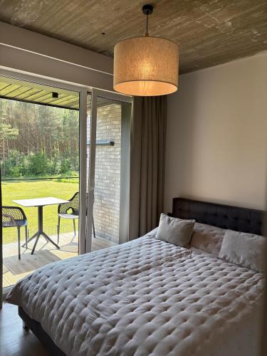 a bedroom with a large bed and a patio at Monciskes Apartment Seaside in Palanga