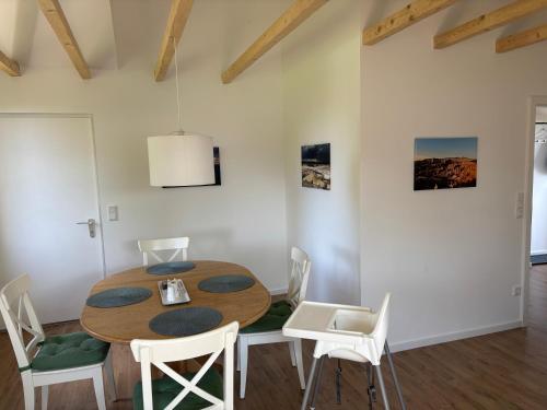 メーネゼーにあるGroße FeWo mit 2 Schlafzimmern in Körbeckeの木製のテーブルと椅子のあるダイニングルーム