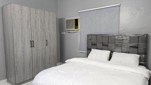 a bedroom with a large white bed and a cabinet at ركن دار الطائف in Taif