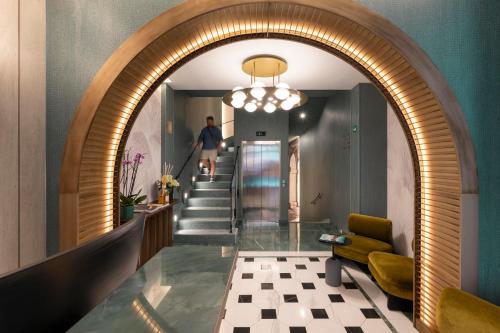 a hallway with an archway and a man walking down the stairs at Je Rome Hotel in Rome
