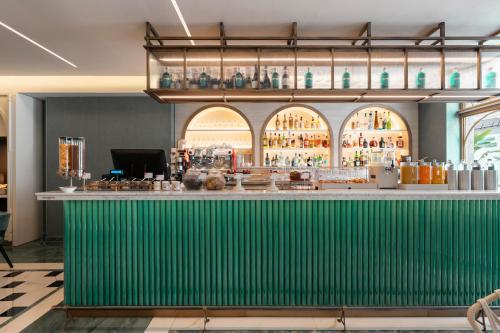 a bar with a green wall in a restaurant at Je Rome Hotel in Rome