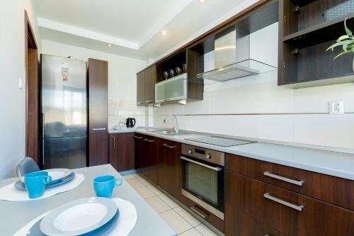 a kitchen with wooden cabinets and a counter with plates on it at NaNoc - noclegi obok lubelskich szpitali i centrum Lublina in Lublin