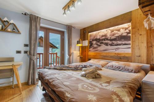 a bedroom with a bed with a painting on the wall at La chambre d'Emilie - romantic room in Valtournenche