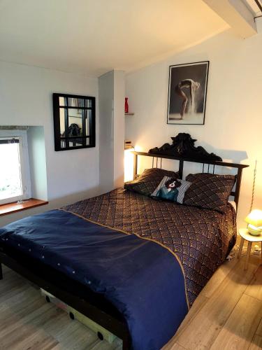 une chambre avec un lit avec une couette bleue dans l'établissement Le Refuge, à Peyriac-Minervois