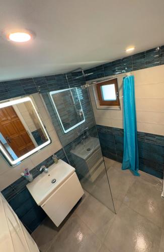 a bathroom with a sink and a shower at Panorama House Lipno in Jenišov