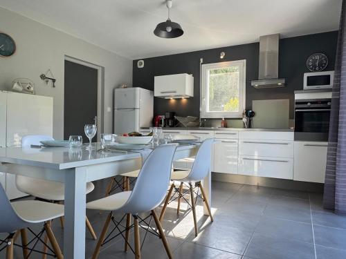 a kitchen with a table and chairs in a kitchen at Maison 8 personnes 5 minutes à pieds de la plage in Sarzeau