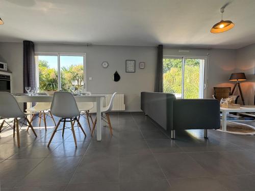 a dining room and living room with a table and chairs at Maison 8 personnes 5 minutes à pieds de la plage in Sarzeau