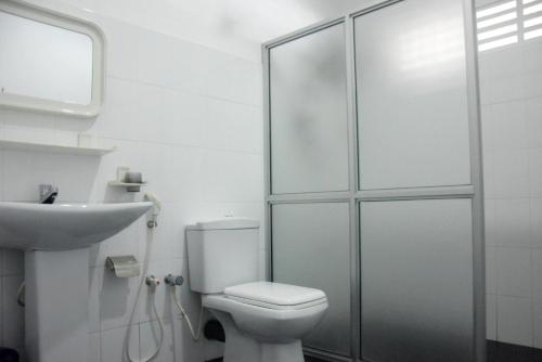 a white bathroom with a toilet and a sink at Hotel Romi Gampaha in Gampaha