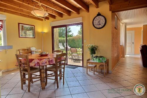 une salle à manger avec une table et une horloge au mur dans l'établissement Kergadic Gite de Saint Guénolé, à Trévou-Tréguignec